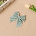 Primer plano de una horquilla con lazo de tela gofrada en color verde claro texturizado - Cian