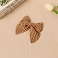 Detalle de un lazo para el pelo en tela waffle marrón oscuro con textura retro única - Marrón