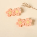 Close-up of embroidered pink flower hair clips with soft fabric lining for baby girls - Orange