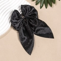 Détail d'un nœud papillon en satin noir avec strass brillants et longs rubans pour cheveux - Noir