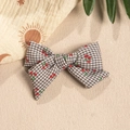 Detailed close-up of brown checkered bow hair clip with cute red cherry print pattern - Gray