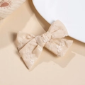 Gros plan sur la barrette à nœud en coton beige avec broderie florale blanche délicate - Blanc Cassé