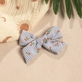 Detail of grey plaid bow hair clip with red cherry patterns on a beige textured background - Light Gray