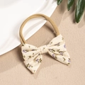 Detailed close-up of a floral bow baby headband with soft nylon elastic and purple flower print - Purple Flower
