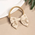 Detail of baby nylon headband with beige floral cotton bow in a natural setting - Brown Floral Style (5)