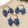 Detail view of denim bow headbands with colored wavy edge stitching and nylon bands - Random Color Style