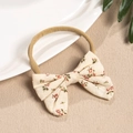 Dettaglio fascia per neonati in nylon con fiocco floreale in cotone naturale - Piccolo Fiore Rosso