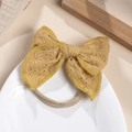 Detailed macro view of mustard yellow cotton eyelet embroidered bow with elastic baby headband - Turmeric
