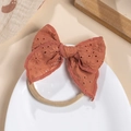 Detailed view of brick red embroidered cotton bow on soft elastic baby headband - Orange Red