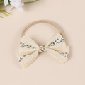 Detailed close-up of cream lace bow with floral embroidery on pink nylon headband - Blue And Red Floral