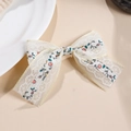 Dettaglio di fermaglio per capelli a fiocco floreale con bordo in pizzo bianco - Floreale Blu e Rosso