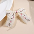 Dettaglio di un fermaglio per capelli in pizzo fatto a mano con ricami floreali rosa vintage - Piccolo Fiore Fucsia