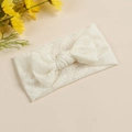 Vue détaillée de la broderie en dentelle blanche et du grand nœud sur le bandeau bébé - Blanc Cassé