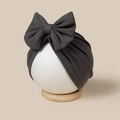 Detail view of dark grey baby turban with large bow and ribbed knit texture on a head model - Dark Gray