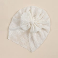 Detail of baby lace bow turban featuring intricate floral patterns and soft mesh texture - Off White
