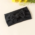 Gros plan d'un bandeau pour bébé noir en tissu gaufré élastique avec un nœud fait main - Noir