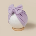 Detailed view of lavender purple newborn turban hat with large bow on white model - Light Purple