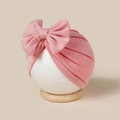 Detail der Textur von rosa gerippter Baby-Turban-Mütze mit großer dekorativer Schleife - Altrosa