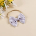 Detail of baby headband featuring purple checkered fabric bow and wave-cut edges - Headband Style / Light Purple