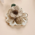 Dettaglio di spilla a fiore in tessuto fatta a mano con petali di lana e base in pizzo retrò - Fiore Intrecciato Stile 1
