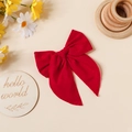 Détail d'une pince à cheveux avec nœud en coton rouge et coutures sur fond en bois - Rouge