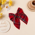 Détail d'une barrette noeud à carreaux rouge et bleu avec couture fine sur fond chaud - Rouge Foncé
