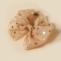 Detail of beige mesh bow hair tie featuring gold foil polka dots and elastic band - Nude