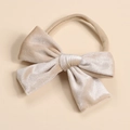 Detail of soft velvet bow baby headband with high-elastic nylon strap in champagne gold - Beige
