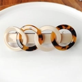 Close-up of interlocking acetate rings hair clip with tortoiseshell and ivory patterns - Dark Tortoiseshell