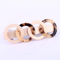 Detail van schildpad en crème acetaat ringen op een gouden haarspeld met veerclip - Beige Schildpad