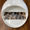 Detail of wide-tooth tortoiseshell hair comb with HK logo in a white ceramic bowl - Amber Tortoiseshell (3)