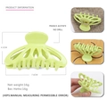 Detail view of a light green acetate hair claw clip with geometric cutout design - Green