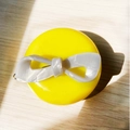 Minimalist white marble pattern acetate bow hair clip on a bright yellow round stand - Pearl White