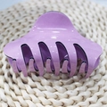 Primer plano de una pinza para el cabello de acrílico violeta brillante sobre fondo de paja - Púrpura