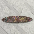 Detail einer bunten Acetat-Haarklammer mit regenbogenfarbener Textur und Metallfeder - Irisierender Treibsand