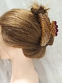 Vintage amber acrylic hair claw clip with gold foil flakes on a brown hair bun - Red Brown Pineapple