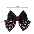 Dettaglio del grande fiocco per capelli a quadri con perle e gemme colorate in rosso e verde - Nero Rosso