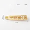 Detail of toothpaste shaped acetate hair clip with golden organic aloe vera text print - Yellow (Engraved)