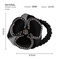 Dettaglio dell'elastico per capelli a camelia in acetato con cristalli champagne - Nero + Strass Fantasma
