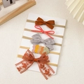 Detail view of five different handmade baby headbands with bows on a display card - Caramel Tone Handmade Bow Match (5)