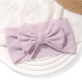Détail du bandeau bébé lilas en tricot côtelé avec un grand nœud sur un support texturé - Mauve Clair