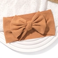 Bandeau bébé côtelé marron clair avec grand nœud sur un plateau blanc décoratif - Beige