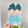 Close-up of three cute bow headbands for babies with ribbed texture on display card - Combination Set / Dark Green Pink Mint Green
