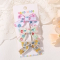 Lot de trois barrettes à nœuds floraux avec bords festonnés sur carte de présentation - Mix Floral Rose Bleu Rose Vert Jaune Bleu (3D)