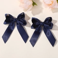 Paar marineblaue Polyester-Satin-Haarschleifen mit langen Bändern auf floralem Hintergrund - Marineblau