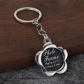 Macro shot of silver flower photo frame keychain with dimensions on wooden background - Flower