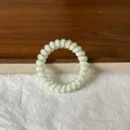 Fashionable white spiral hair tie featuring colorful pastel polka dot patterns for summer - Green