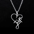 Detalle del colgante de corazón plateado con inscripción faith hueca en cadena de metal - Collar Letra Corazón (Faith)