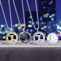 Gemini zodiac necklaces in gold, black, and silver shown next to a coin for scale - Gemini