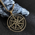 Primer plano de colgante de brújula dorado con grabado N E S W sobre piedra oscura - Oro (Con Cadena de Caja) / Dorado